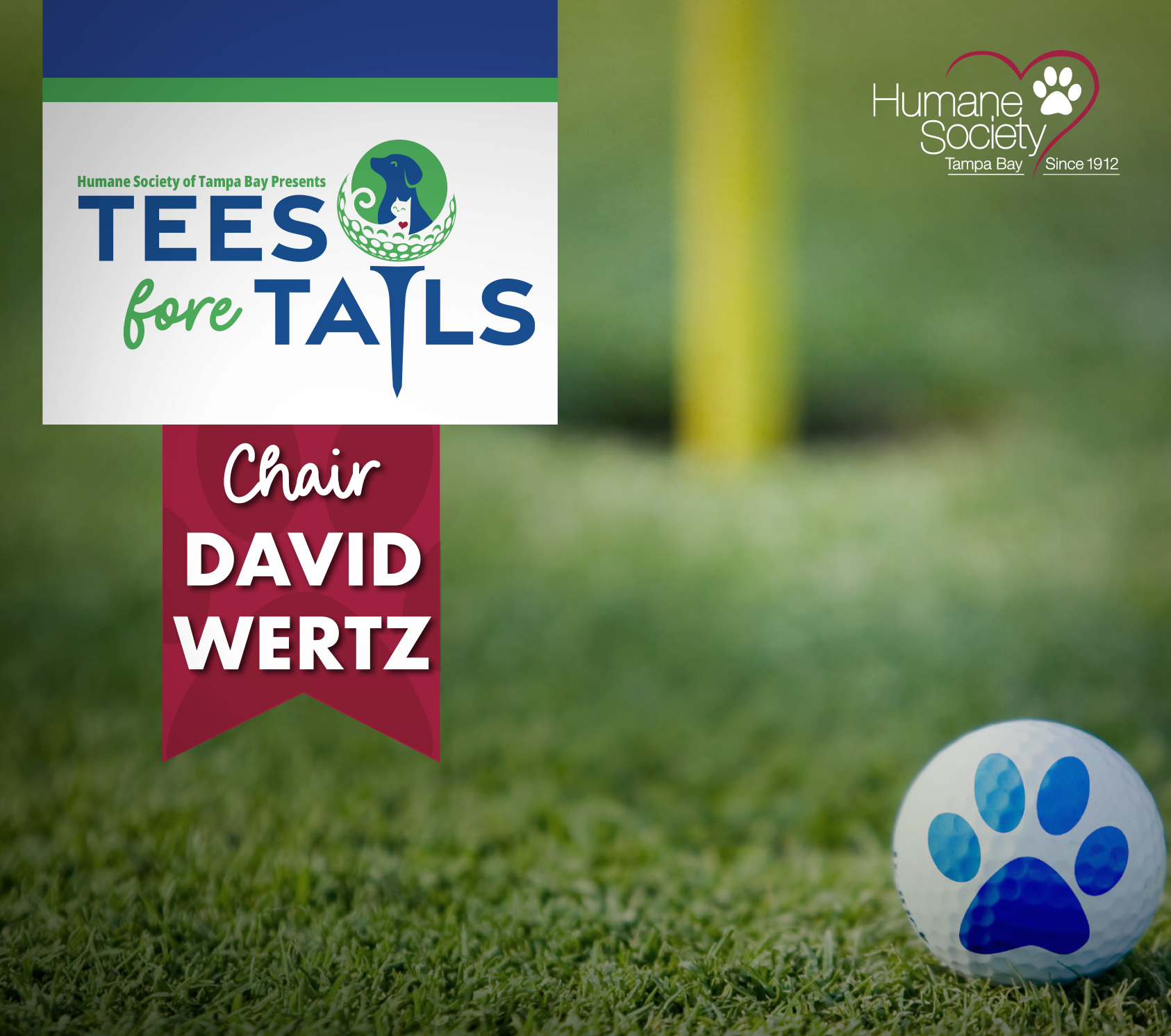 A golf ball with a blue paw print is close up on a golf course with the words "Tees Fore Tails" and "Chair David Wertz"