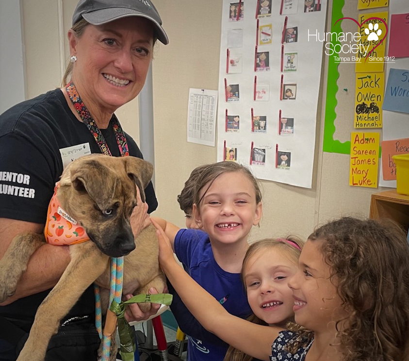 A group of school kids petted an adoptable puppy for HSTB's school presentations.